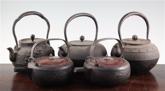 Five Japanese cast iron teapots, two with lacquer covers, 19th century, largest 19cm wide
